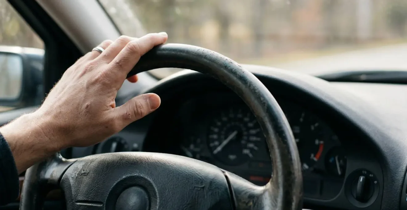 Gros plan sur le volant usé et le tableau de bord d'un véhicule ancien, évoquant le passage du temps et la décision d'adapter son assurance.